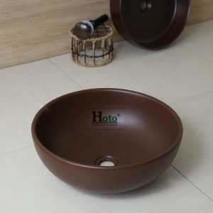 Lavabo bằng sứ màu nâu hình tròn đặt bàn.